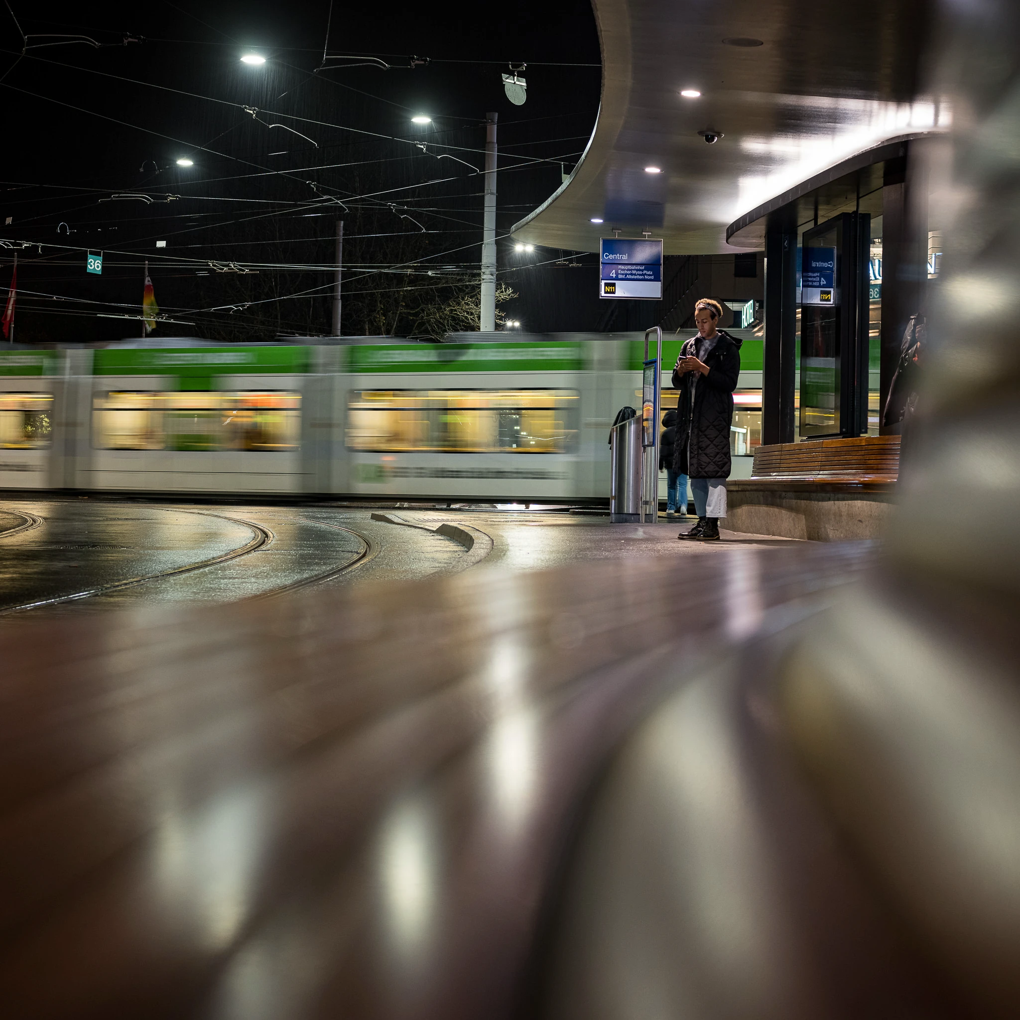 Vorbeifahrendes Tram am Zürich Central mit Bewegungsunschärfe und Reflexionen