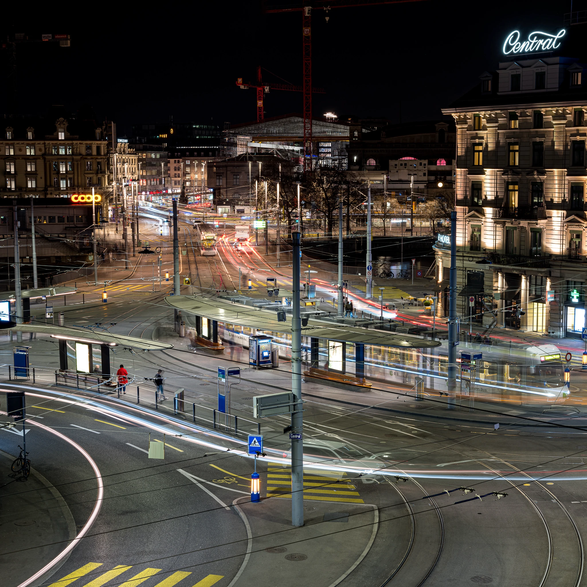 Blick über das Zürich Central mit Tram, Verkehr und Lichtspuren bei Nacht
