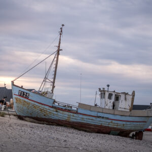 Ein Fotograf fotografiert einen alten Fischkutter an der Ostküste Dänemarks.