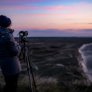 Einzelne Fotografin während der Blauen Stunde auf dem Bulbjerg Knude Fuglefjeld und fotografiert die dänische Ostküste.