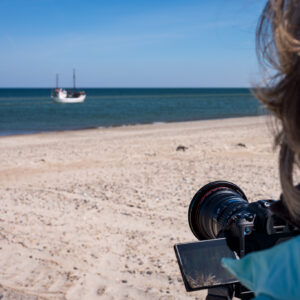 Eine Fotografin fotografiert ein Schiff auf dem Meer in Dänemark.