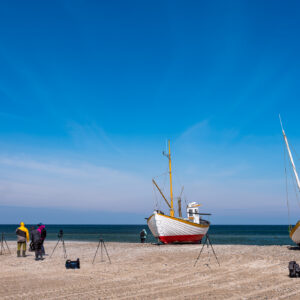 Mehrere Fotografen suchen eine gute Perspektive, um ein Schiff in Dänemark zu fotografieren.