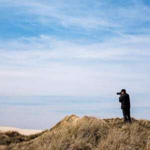 Einsamer Fotograf in einer Dünenlandschaft in Dänemark.