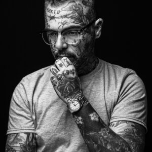 Porträt von einem Mann mit vielen Tätowierungen.