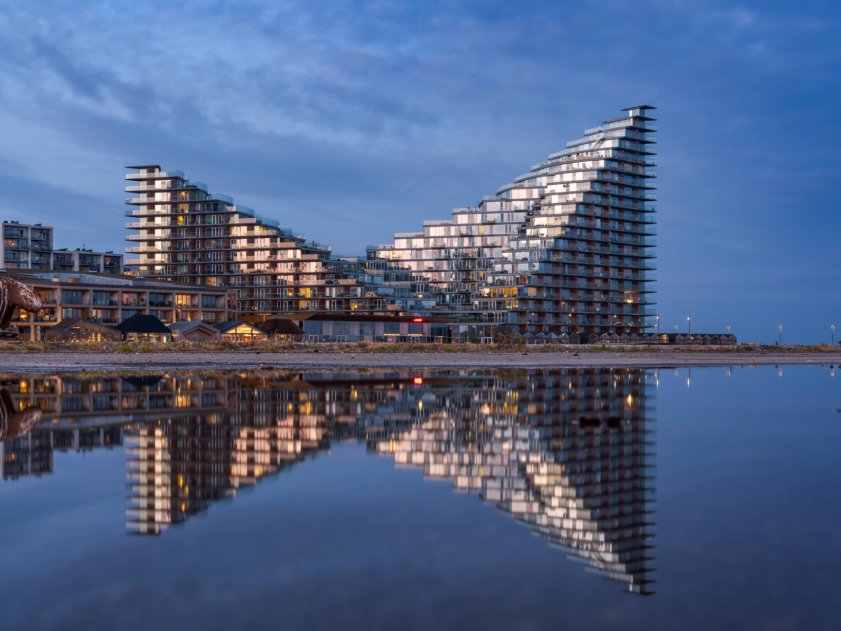 Moderne Hochhaustürme in der blauen Stunde mit perfekter Spiegelung im stillen Wasser – Bildgestaltung durch Kameraperspektive, Symmetrie und Komposition.