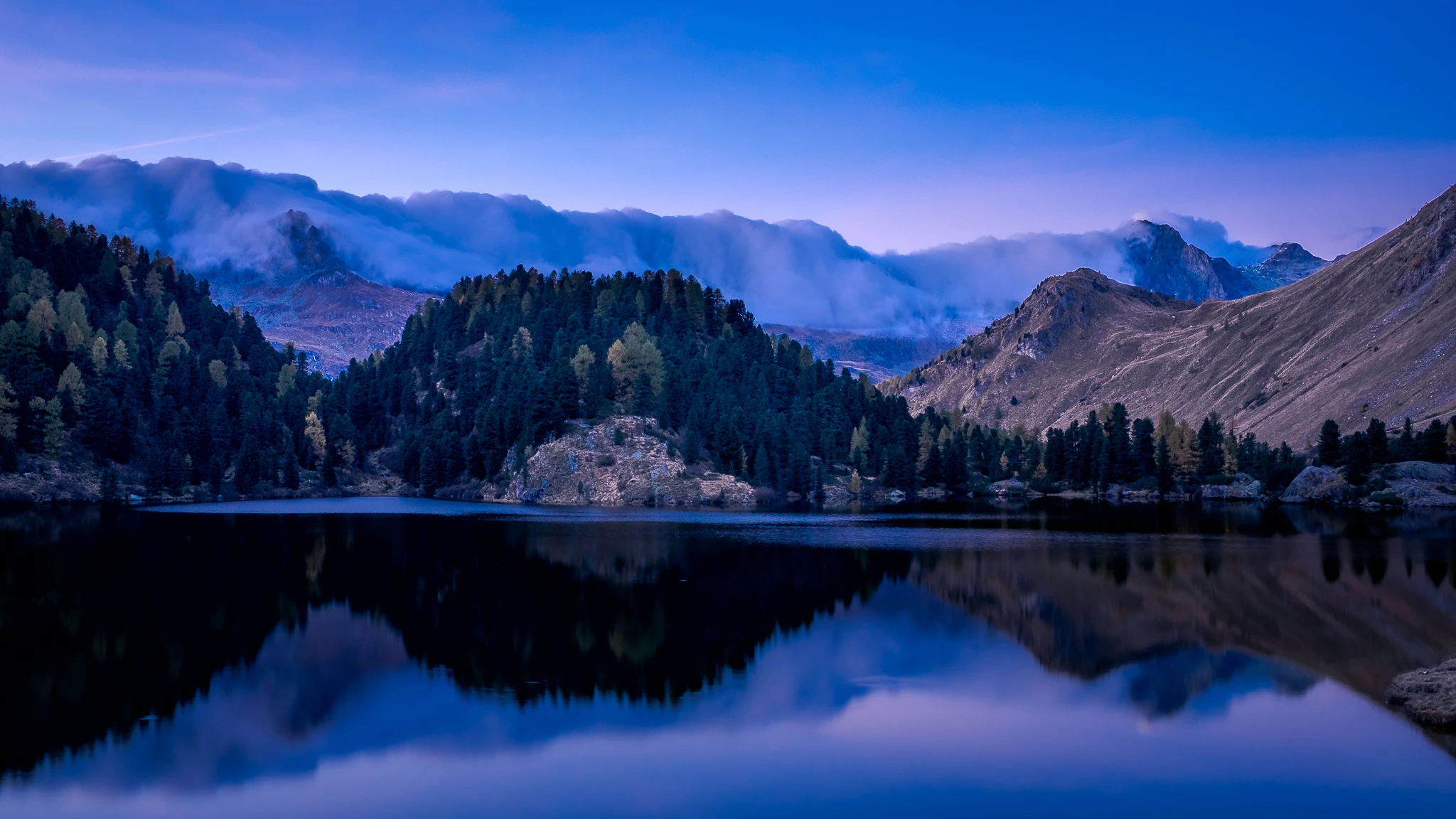Blaue Stunde fotografieren – Bergsee mit Wolkenspiegelung und Bergwald in der Dämmerung