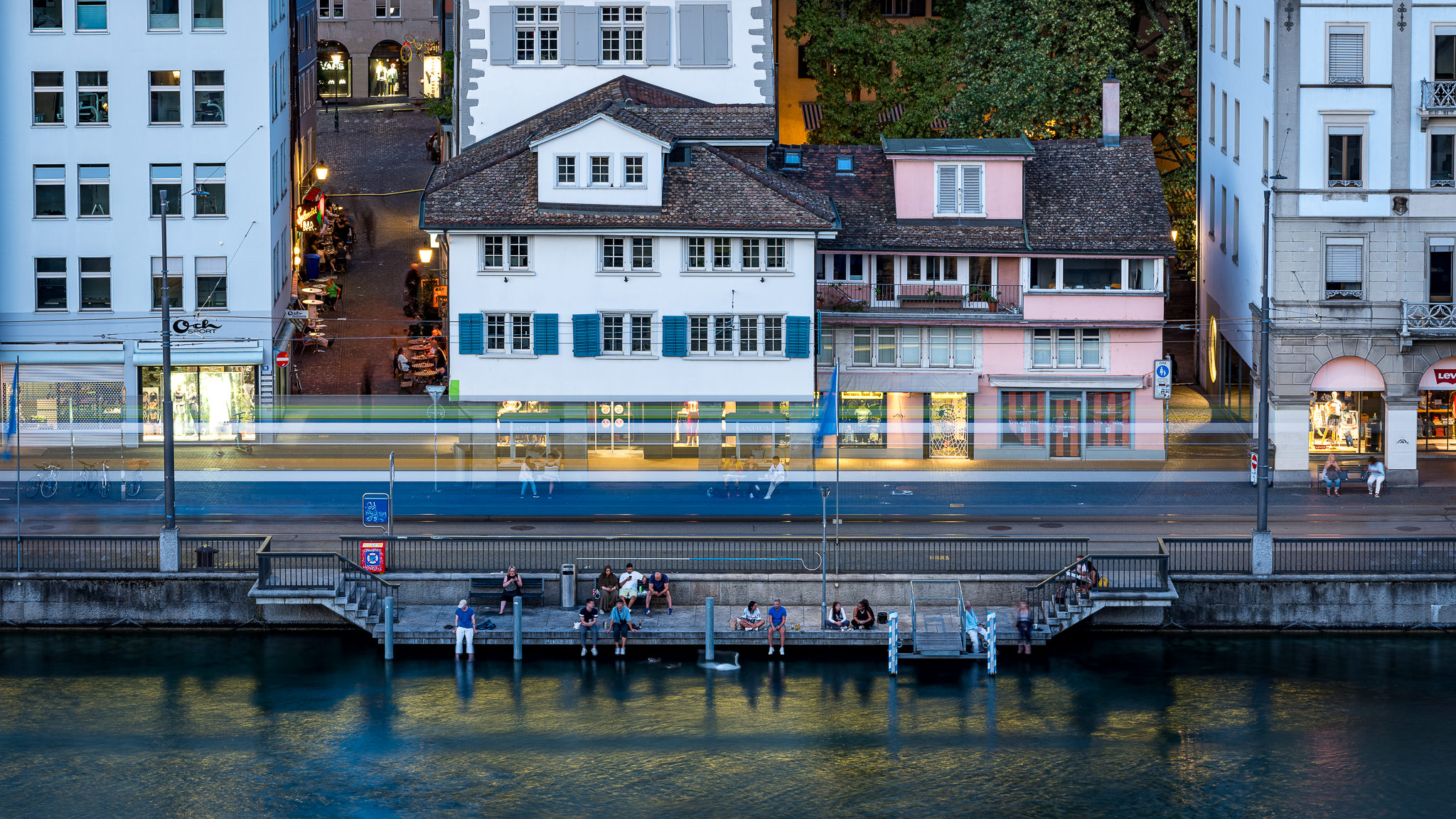 FotoKurs Zürich: Langzeitbelichtung eines Trams vor Altstadthäusern an der Limmat zur blauen Stunde.