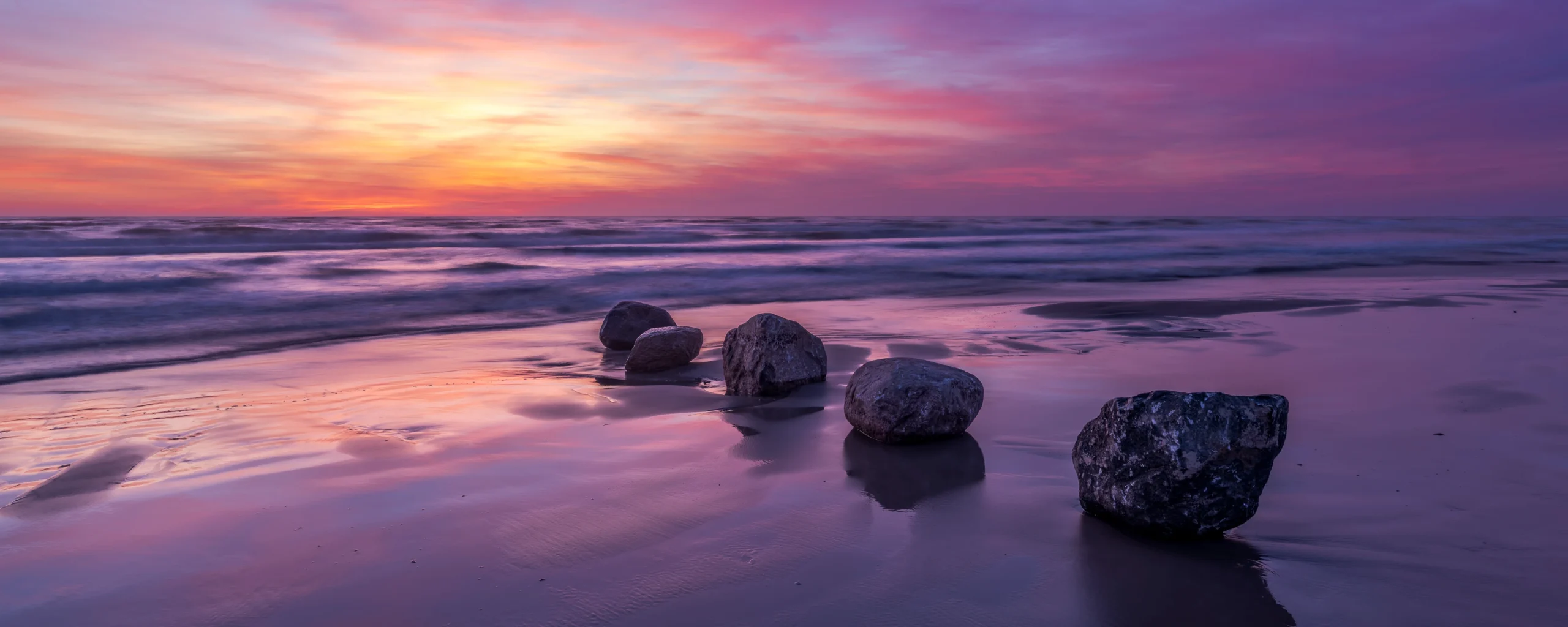 Felsen am Meer bei Sonnenuntergang mit weich fliessendem Wasser