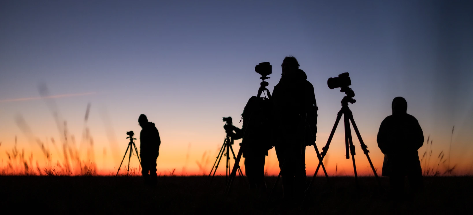 Fotografen mit Kameras und Stativen in der Abenddämmerung